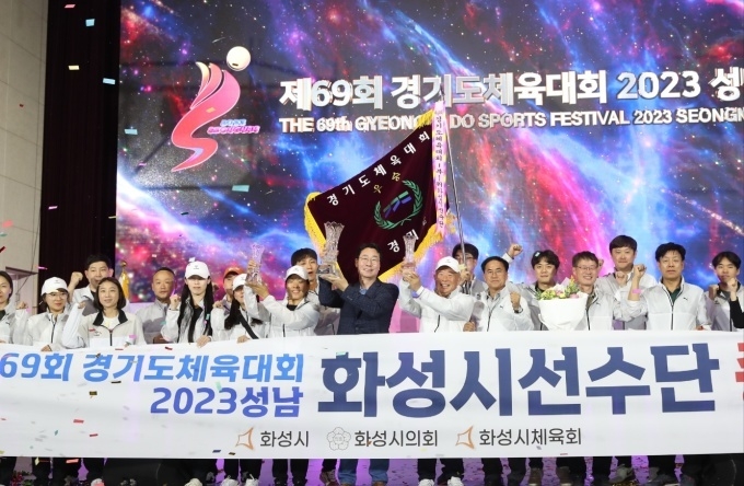 성남시에서 치러진 제69회 경기도체육대회에서 화성시가 1부 종합우승을 차지해 정명근 화성시장(사진중앙)이 우승컵을 들어올리고 선수단과 기념촬영( 사진제공/화성시)