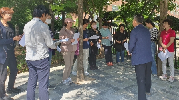 지난 17일 인천 남동구 구월1동 성리중 앞에서 지역주민들이 구 관계자에게 안심마을 조성 보고를 듣고 있다. ( 사진 = 남동구 제공 )
