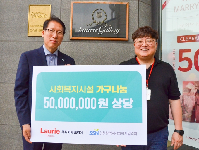 지난 18일 인천 서구 가좌동 로리에 본사 앞에서 전흥윤 인천사회복지협의회 사무처장(왼쪽)과 이진상 로리에 대표이사가 기념촬영을 하고 있다. ( 사진 = 인천사회복지협의회 제공 )