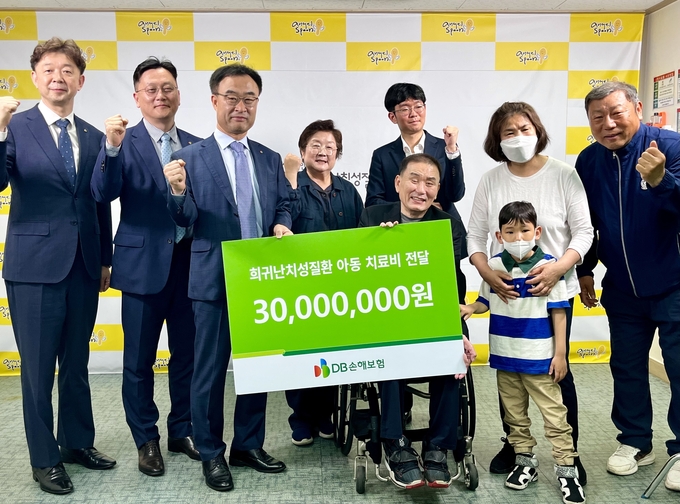 박성식 DB손해보험 부사장(왼쪽 세 번째)과 임직원들이 지난 19일 환우 가족, 한국희귀난치성질환 연합회 직원들과 함께 치료비 전달 및 기념촬영을 하고 있다. (사진=DB손해보험 제공)