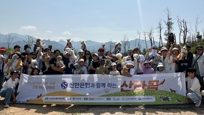 지난 20일 강원도 고성군 성천리 일대에서 진행된 ‘신한은행과 함께하는 산타독(Dog) 봉사활동’에서 참가자들이 봉사활동 후 기념촬영을 하고 있다. (사진=신한은행 제공)