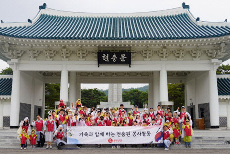 롯데건설 임직원과 가족들이 현충문 앞에서 봉사활동 후 기념촬영을 하고 있다. (사진=롯데건설 제공)