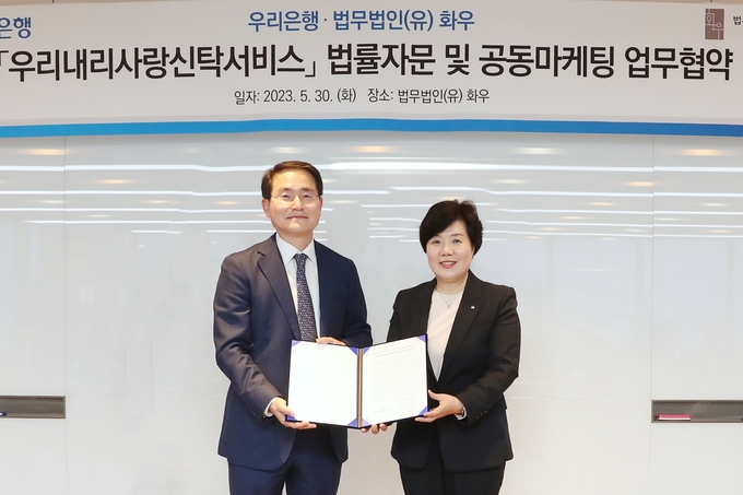 (왼쪽부터) 이명수 법무법인 화우 대표변호사와 송현주 우리은행 자산관리그룹장이 지난 30일 업무협약식에서 기념촬영을 하고 있다. (사진=우리은행 제공)