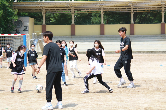 지난 30일 성남시 하탑초에서 진행된 찾아가는 축구교실 '까치 함께'에 참여한 프로축구 K리그2 성남FC 선수들과 하탑초 학생들이 미니게임을 하고 있다. (사진=성남FC 제공)