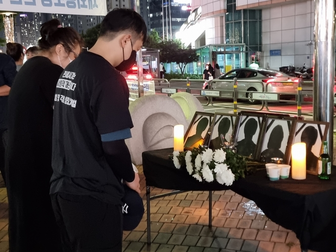 지난 3일 오후 인천 미추홀구 주안역 남광장에서 열린 합동추모제에 참석한 시민들이 얼굴 없는 영정 앞에서 묵념하고 있다. ( 사진 = 김민지 기자 )