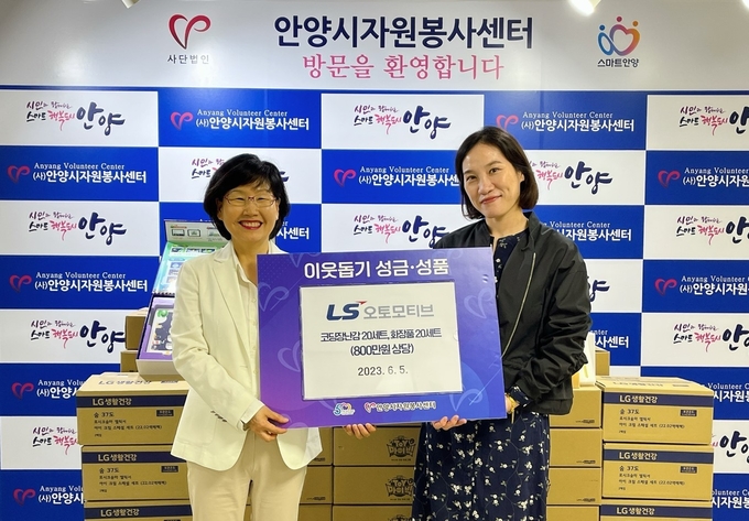 LS오토모티브 회사 관계자가 정옥란 안양시자원봉사센터 소장(왼쪽)에게 후원품을 기탁하고 있다. (사진=안양시 제공)