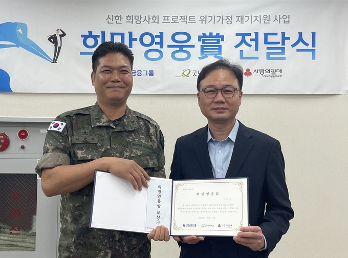 최우현 신한은행 북부본부장(오른쪽)이 지난 5일 62번째 ‘희망영웅상’ 전달식에서 희망영웅으로 선정된 이은재 상사와 기념촬영을 하고 있다. (사진=신한금융그룹 제공)