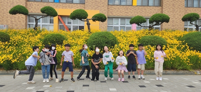 아름다운 환경 속에서 자라는 김포대명초 학생들이 친화적으로 만든 화단 앞에서 풀쩍 뛰고 있다. 김포대명초제공 
