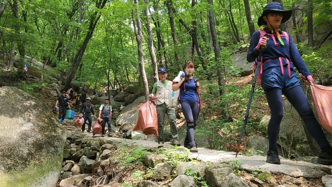 무한산악회 회원들이 수락산장에서 부터 폐 건자재 등을 포대에 담아 운반하고 있다.(사진=무한산악회 제공)