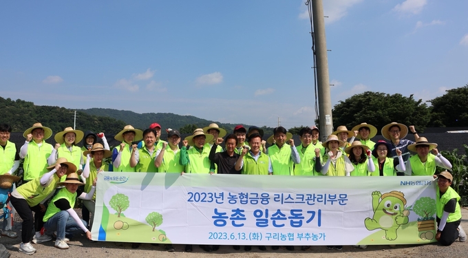 강신노 농협은행 리스크관리부문 부행장(첫줄 오른쪽 9번째)과 직원들이 일손 돕기를 실시하고 기념촬영을 하고 있다. (사진=NH농협은행 제공)