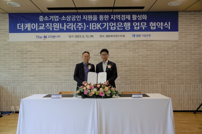 (왼쪽부터) 이상목 더케이교직원나라 대표이사와 박청준 기업은행 개인고객‧카드사업그룹장이 협약식을 마치고 기념촬영을 하고 있다. (사진=IBK기업은행 제공)
