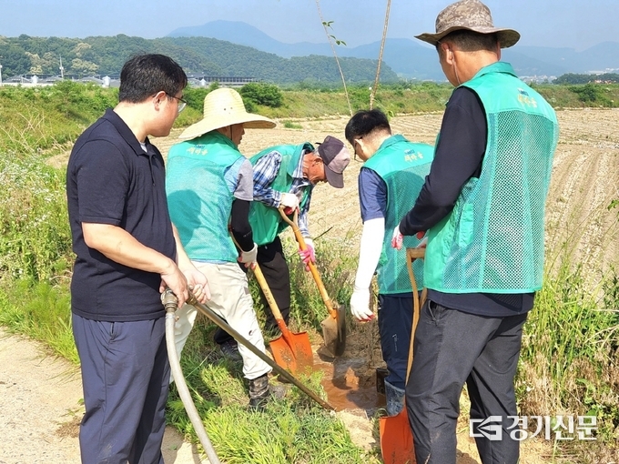 양성면 새마을회 회원들이 한천 꽃길을 가꾸고 있다. (사진=안성시 제공)