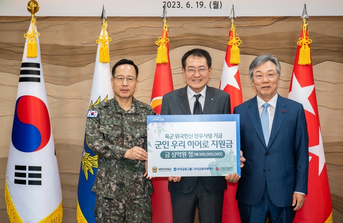 (왼쪽부터) 박정환 육군참모총장, 장광익 우리금융지주 부사장, 성우종 충남사회복지공동모금회 회장이 지원금 전달식에서 기념촬영을 하고 있다. (사진=우리금융미래재단 제공)