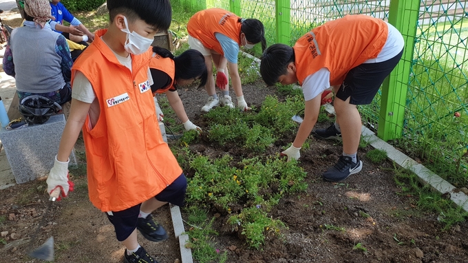 양평군종합자원봉사센터 가족봉사단 단원들이 갈산공원 화단 봉사활동을 하고 있다. (사진=양평군 제공)
