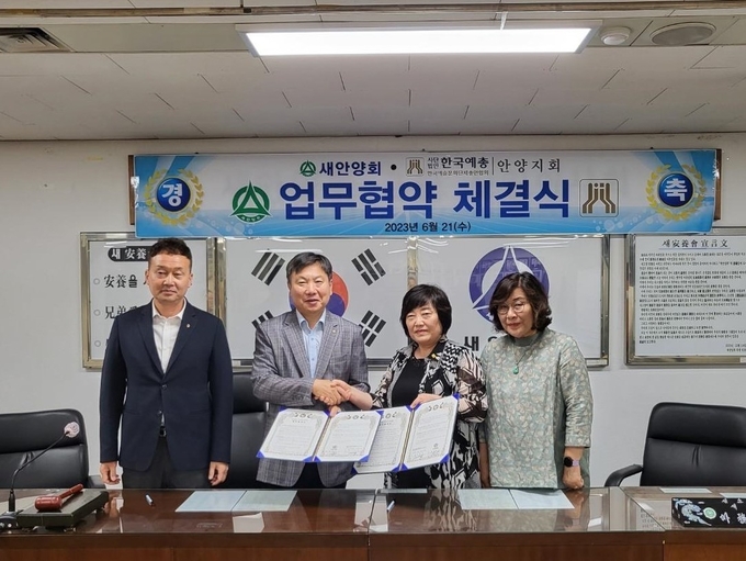 이재옥 안양예총 지회장(오른쪽 두번째)과 조문수 새안양회 회장(세번째)이 협약서에 서명한 뒤 악수를 나누고 있다. (사진=안양예총 제공)