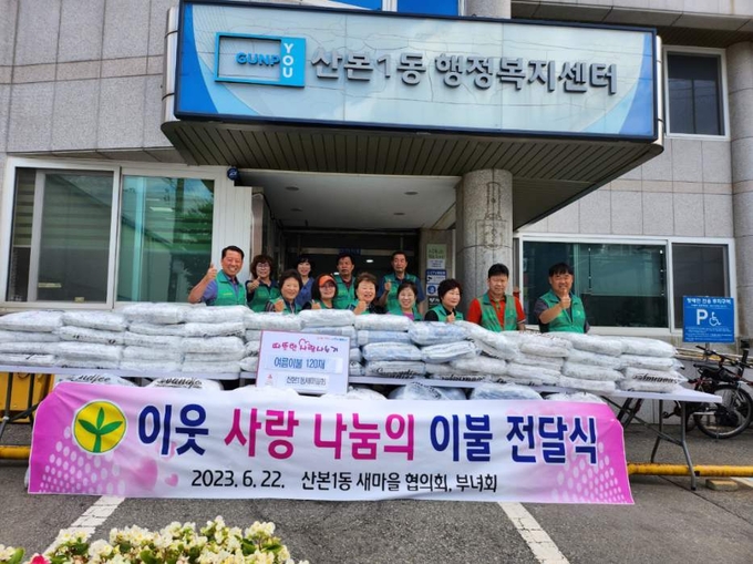 군포시 새마을 지도자 협의회와 새마을 부녀회가 바자회 수익금으로 이불을 전달하고 있다. (사진 = 군포시 제공)