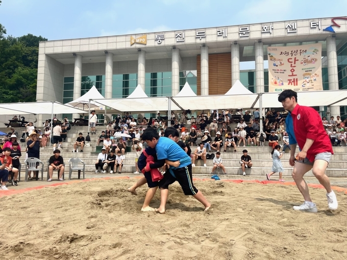 씨름 결승에서 맞붙고 있는 어린이 선수 2명이 샅바를 잡고 기회를 잡으려고 돌고 있다. (사진=김포시 제공)