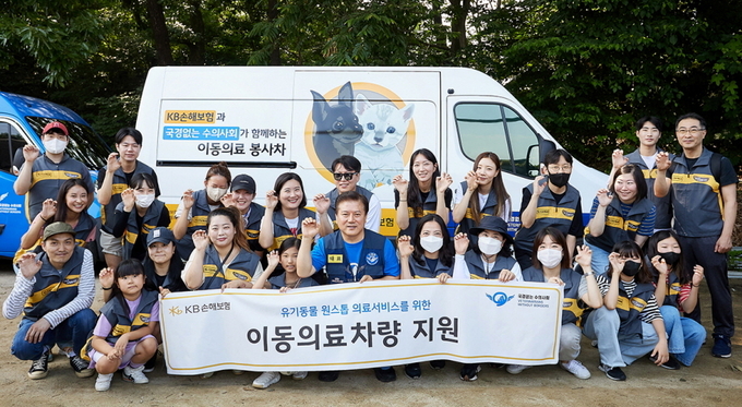 최선영 KB손해보험 ESG전략유닛장(윗줄 왼쪽 5번째)과 KB손보 임직원들이 이동의료차량 전달식에서 김재영 국경없는 수의사회 대표(아랫줄 왼쪽 6번째)와 기념촬영을 하고 있다.(사진=KB손해보험 제공)