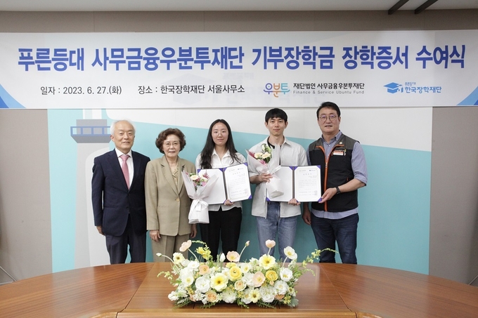 27일 한국장학재단 서울사무소 대회의실에서 배병일 한국장학재단 이사장(왼쪽 1번째), 신필균 사무금융우분투재단 이사장(왼쪽 2번째), 이재진 전국사무금융서비스 노동조합 위원장(오른쪽 1번째)이 장학증서 수여식에 참석하여 장학생들과 기념 촬영을 하고 있다. (사진=한국장학재단 제공)