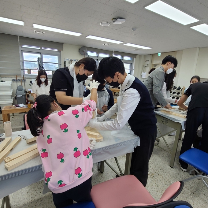 대광초등학교 학생들과 대광중학교 학생들이 함께 목공 수업에 참여하고 있다. (사진=대광초중등학교 제공)