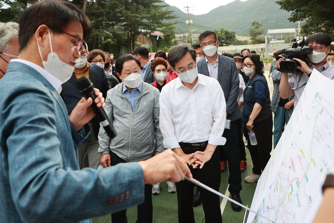 주광덕 시장과 김동연 경기도지사가 지방도 387호선 사업 구간 현장에서 보고를 받고 있다.(사진=남양주시 제공)