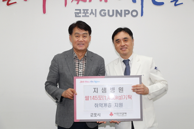군포 지샘병원 강제구병원장이 하은호시장에게 쌀을 기탁하고 있다. (사진=군포 지샘병원 제공)