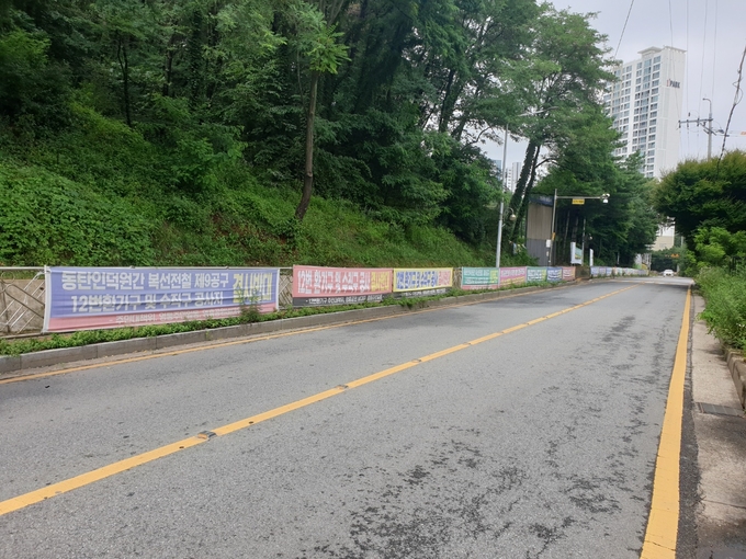 수원시 영통구에 위치한 동인선 9공구 환풍구 건설 예정지 인근. 환풍기 위치 변경을 요구하는 현수막이 걸려 있다. (사진=나규항 기자)
