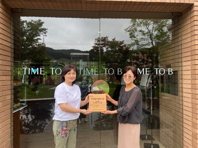 용인특례시 성복동 협의체가 베이커리 카페 ‘타임투비’에 현판을 전달하고 있다. (사진=용인시 제공)
