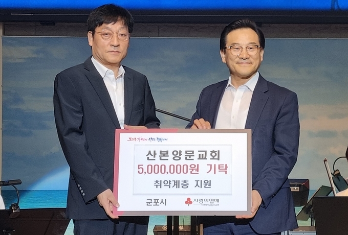 산본양문교회가 취약계층을 위해 500만 원을 군포시에 기탁하고 있다. (사진=군포시 제공)