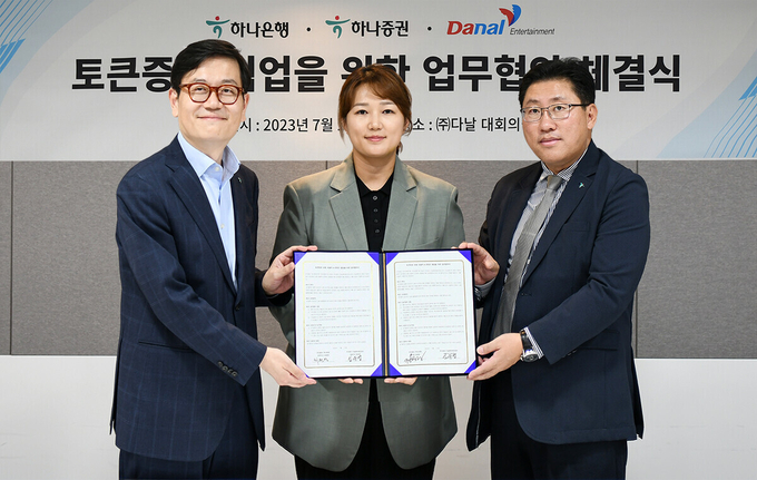 (왼쪽부터) 정재욱 하나은행 디지털전략본부장, 임유엽 다날엔터테인먼트 대표, 최원영 하나증권 디지털본부 상무가 협약서를 들고 기념촬영을 하고 있다. (사진=하나은행 제공)