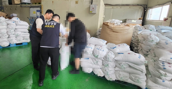 인천해양경찰서 경찰관들이 인천의 한 수산물 유통업체 창고에 쌓여 있는 중국산 천일염을 조사하고 있다. ( 사진 = 인천해양경찰서 제공 )