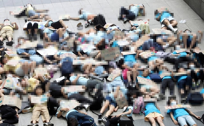 지난 5일 수원시청사 광장에서 A초등학교 학생들이 환경 캠페인 도중 '다이-인(Die-in) 퍼포먼스'를 하고 있다. (사진=수원시의회 제공)