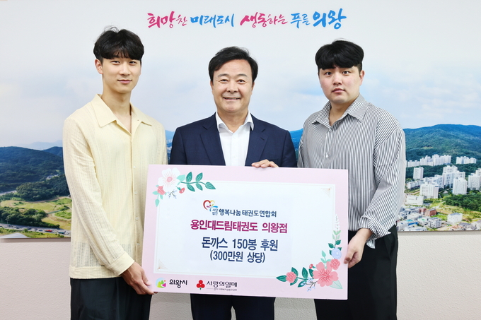 배상문 용인대드림태권도 의왕점 관장이 김성제 의왕시장에게 300만 원 상당의 돈가스 150봉을 전달하고 있다. (사진=의왕시 제공)