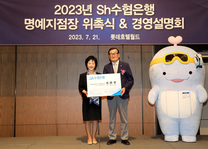 강신숙 Sh수협은행장(왼쪽)이 지난 21일 세종금융센터 명예지점장으로 선정된 오응준 고객에게 위촉장과 특별명함을 전달하고 기념촬영을 하고 있다. (사진=Sh수협은행 제공)