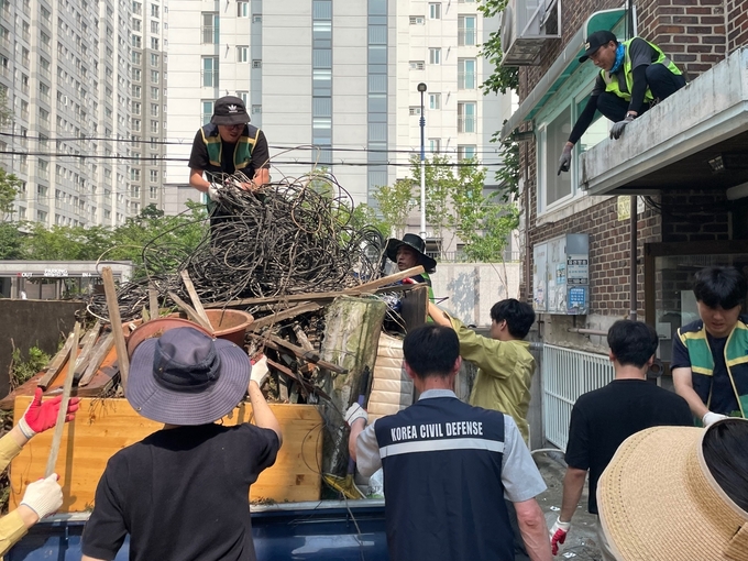 지난 21일 오후 인천 남동구 만수1동 빌라 앞에서 적치물을 트럭에 싣고 있다. ( 사진 = 남동구 제공 )