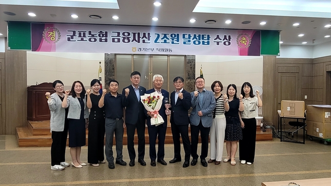 이명근 군포농협 조합장과 직원들이 상호금융자산 2억 원 달성 탑 수상을 축하하고 있다. (사진=군포농협 제공)
