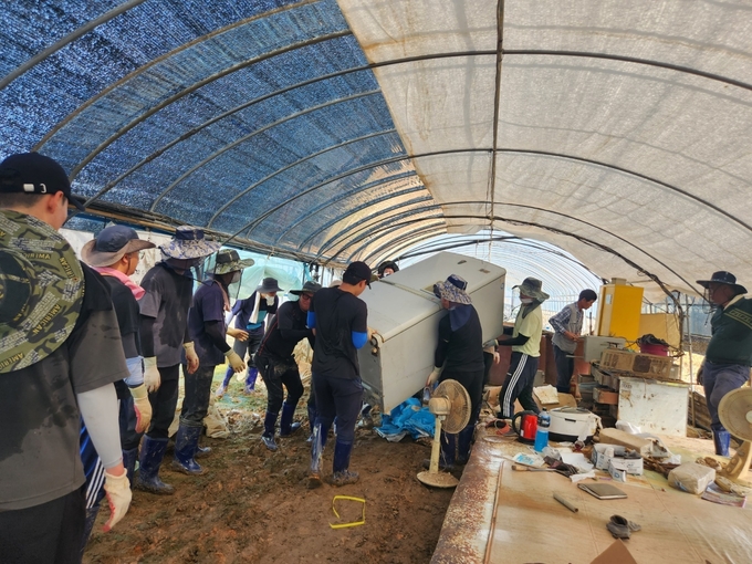 한국농어촌공사 임직원들이 수해를 입은 한 농가에서 복구작업을 하고 있다. (사진=한국농어촌공사 제공) 