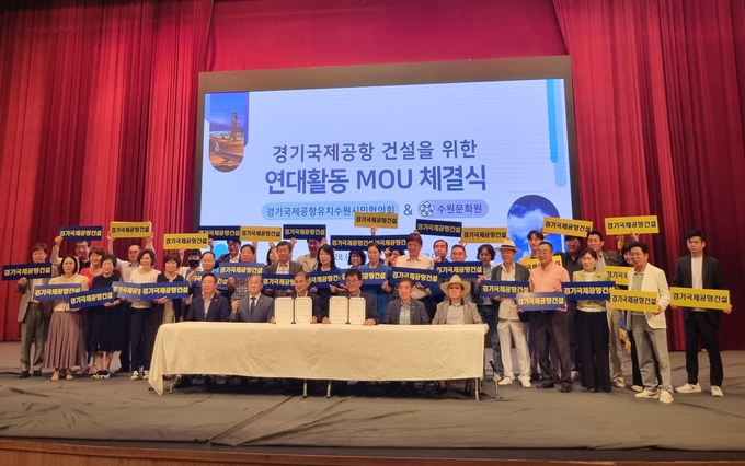 지난 28일 수원시민회관 대강당에서 열린 협약식에서 경기국제공항유치수원시민협의회와 수원문화원 관계자들이 기념 촬영을 하고 있다. (사진=수원시 제공)