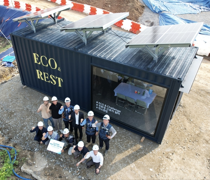 포스코이앤씨가 개발한 태양광 이동식 건설 노동자 쉼터 ‘ECO & REST’ 앞에서 관계자들이 기념촬영을 하고 있다. ( 사진 = 포스코 제공 )