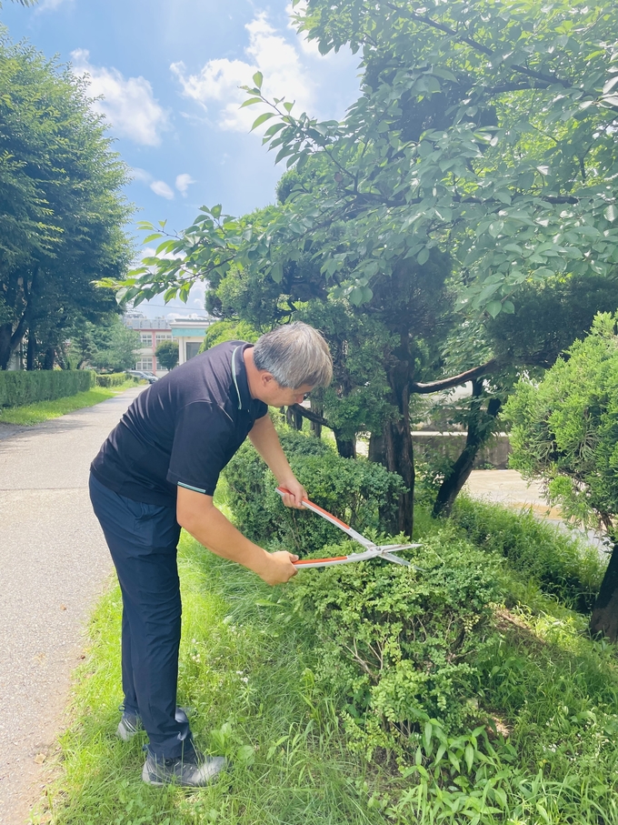  발안바이오과학고등학교 조경 관리 중인 최병환 시설관리직 주무관. (사진=발안바이오과학고등학교 제공)