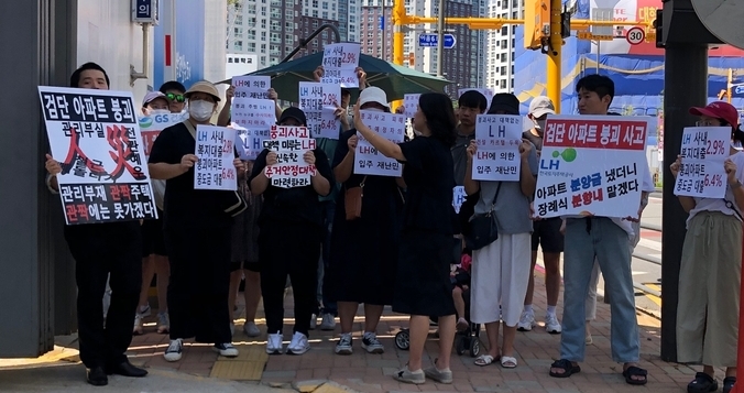 지난 4일 민주당 민생채움단 주재로 열린 검단신도시 아파트 부실시공현장 방문에서 입주예정자들이 피켓을 들고 서있다. ( 사진 = 박소영 기자 )