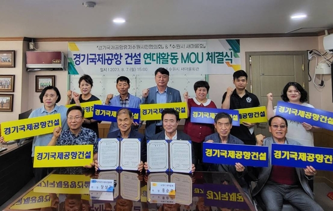 지난 7일 수원시새마을회 회의실에서 열린 협약식에서 경기국제공항유치수원시민협의회와 수원시새마을회 관계자들이 기념 촬영을 하고 있다.