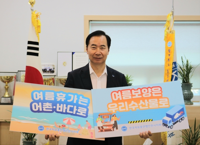 이정태 회장이 어촌 휴가를 장려하고 수산물의 소비 촉진을 위한 캠페인에 참여해 기념촬영을 하고 있다. ( 사진 = 한국자유총연맹 인천시지부 제공 )
