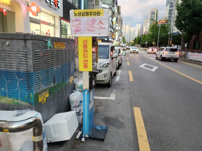 지난 8일 오후 인천 연수구 옥련동 옥련시장 노상 공영주차장에 설치된 주차요금 무인정산기 주변에 쓰레기봉투가 널려있다. ( 사진 = 박지현 기자 )