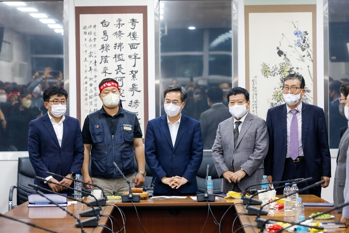 지난해 9월 30일 새벽 경기도 수원시 권선구 탑동에 위치한 한국노총 경기지역본부에서 경기도 버스 노사가 재협상 타결 후 김동연 경기도지사와 경기도 버스 노사 양측 대표단이 기자회견을 하고 있다. (사진=경기도 제공)