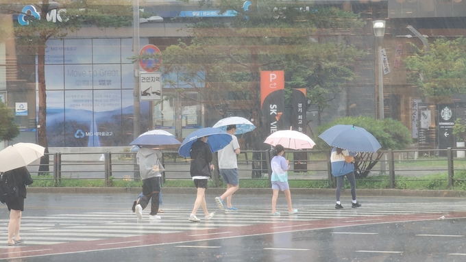  10일 제6호 태풍 ‘카눈’이 한반도에 상륙한 가운데 폭우 속 보행자들. (사진=박진석 기자)