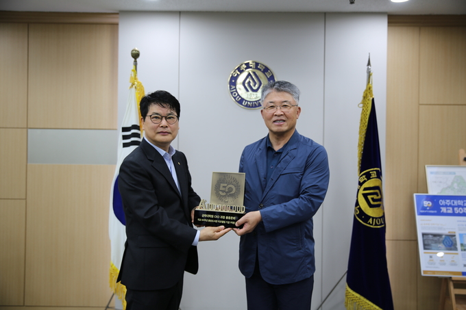 한상필 회장이 학교 발전 기금 1억 원을 최기주 아주대 총장에게 전달하고 있다. (사진=총동문회 제공)