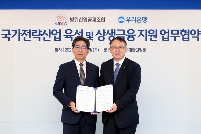 이필수 방위산업공제조합 부이사장과 정진완 우리은행 중소기업그룹장이 협약식 이후 기념촬영을 하고 있다. (사진=우리은행 제공)
