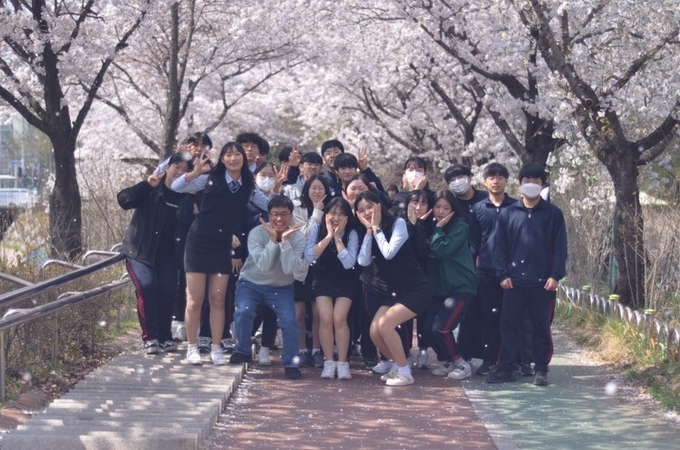  교사와 학생들이 벚꽃 아래에서 즐겁게 사진을 찍는 모습. (사진=덕산고등학교 제공)