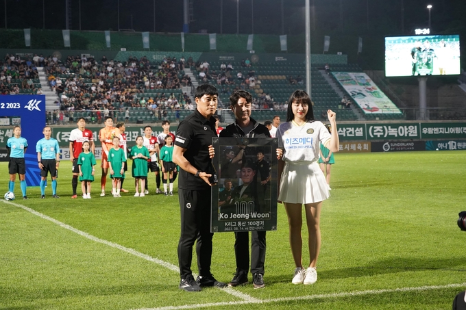 프로축구 사령탑으로 K리그 100경기 출전 기록을 세운 김포FC 고정운 감독(왼쪽)이 홍경호 김포FC 대표이사(가운데)로부터 기념 액자를 전달받은 뒤 기념사진을 찍고 있다. (사진=김포FC 제공)